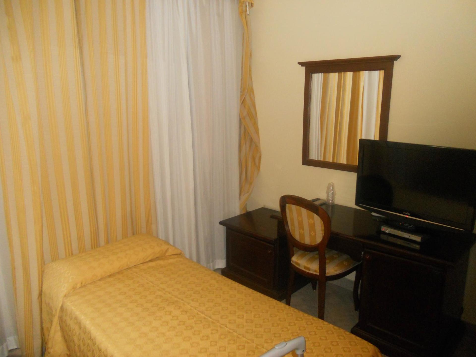 Una camera nel nostro hotel 2000 a Olbia con un letto singolo e una TV a schermo piatto