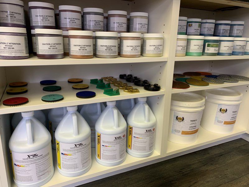 Shelves stocked with labeled bottles, jars, and containers of chemicals in a storage room