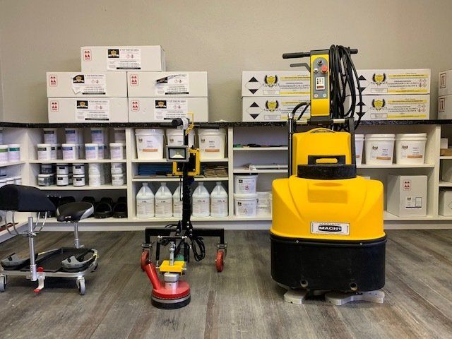 Yellow floor-cleaning machine in a storage room with shelves of cleaning supplies and boxes