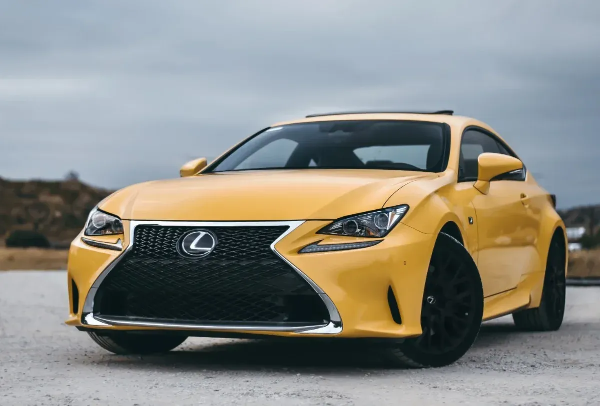 Yellow Lexus sports car parked outdoors on a cloudy day