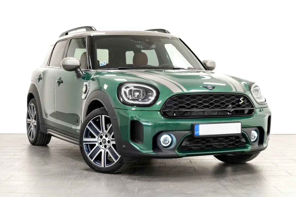 Green Mini Cooper SUV in a studio setting, shown from the front-left angle.