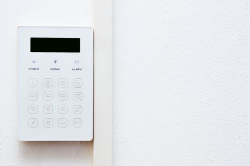 Un sistema di sicurezza bianco è montato su una parete bianca.