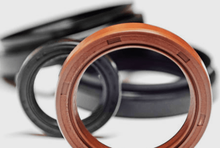 Close-up of several black and brown rubber oil seals, one in focus.