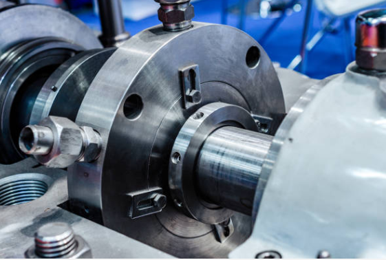 Close-up of industrial machinery, showing metal components, bolts, and tubing, possibly a pump or engine.