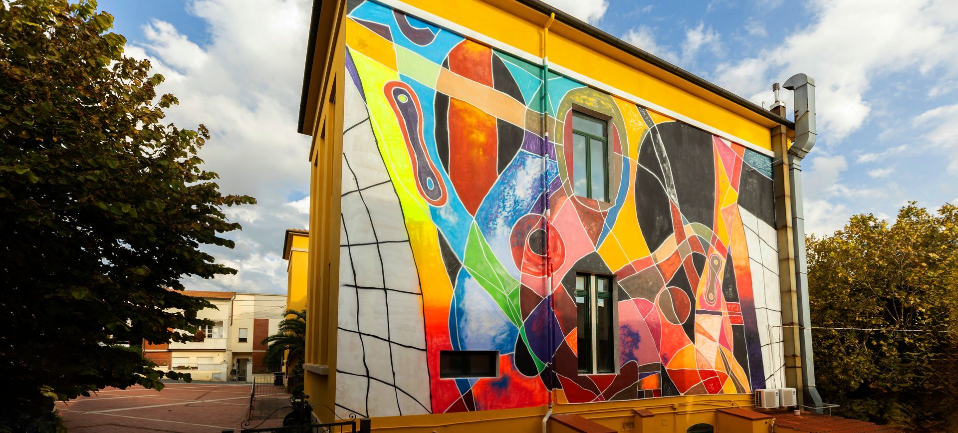 Riparbella01, murale astratto di Moneyless sulla facciata laterale dell'edificio scolastico di Piazza Guglielmo Marconi a Riparbella