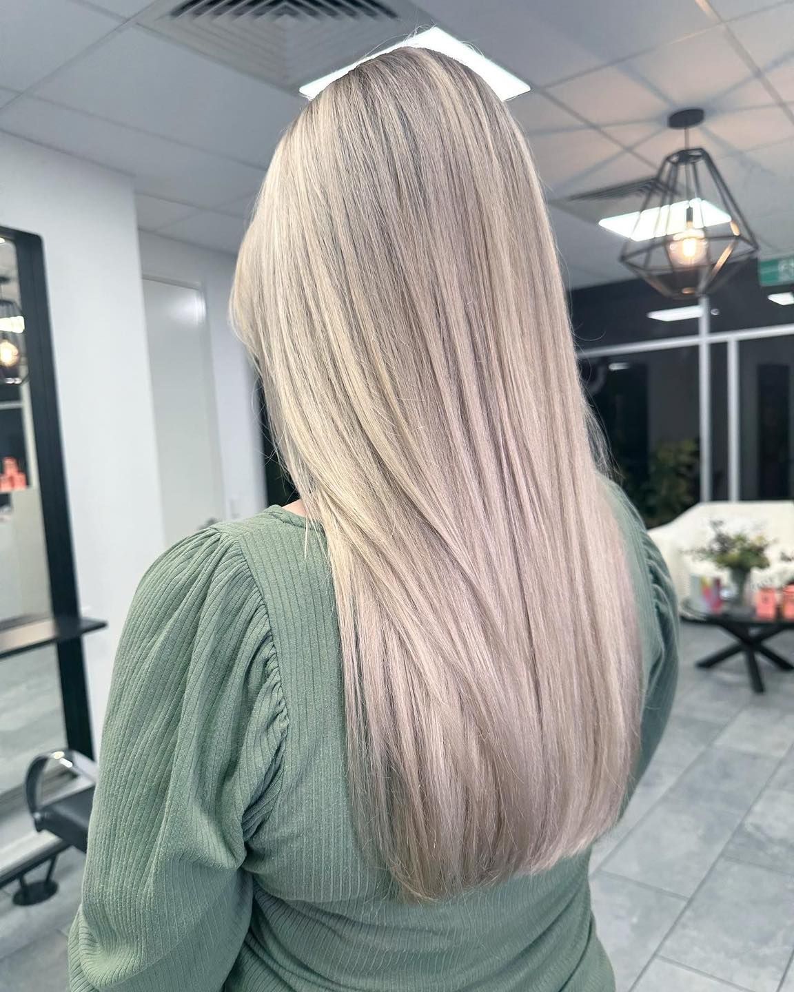 A Woman With Long Blonde Hair Is Standing In A Salon — Blackwell Hair In Woree, QLD