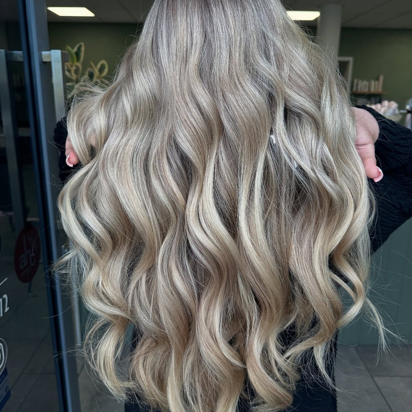 Long Wavy Ash-blonde Hair With Dark Roots, Shown From Behind In A Salon Setting — Blackwell Hair In Woree, QLD