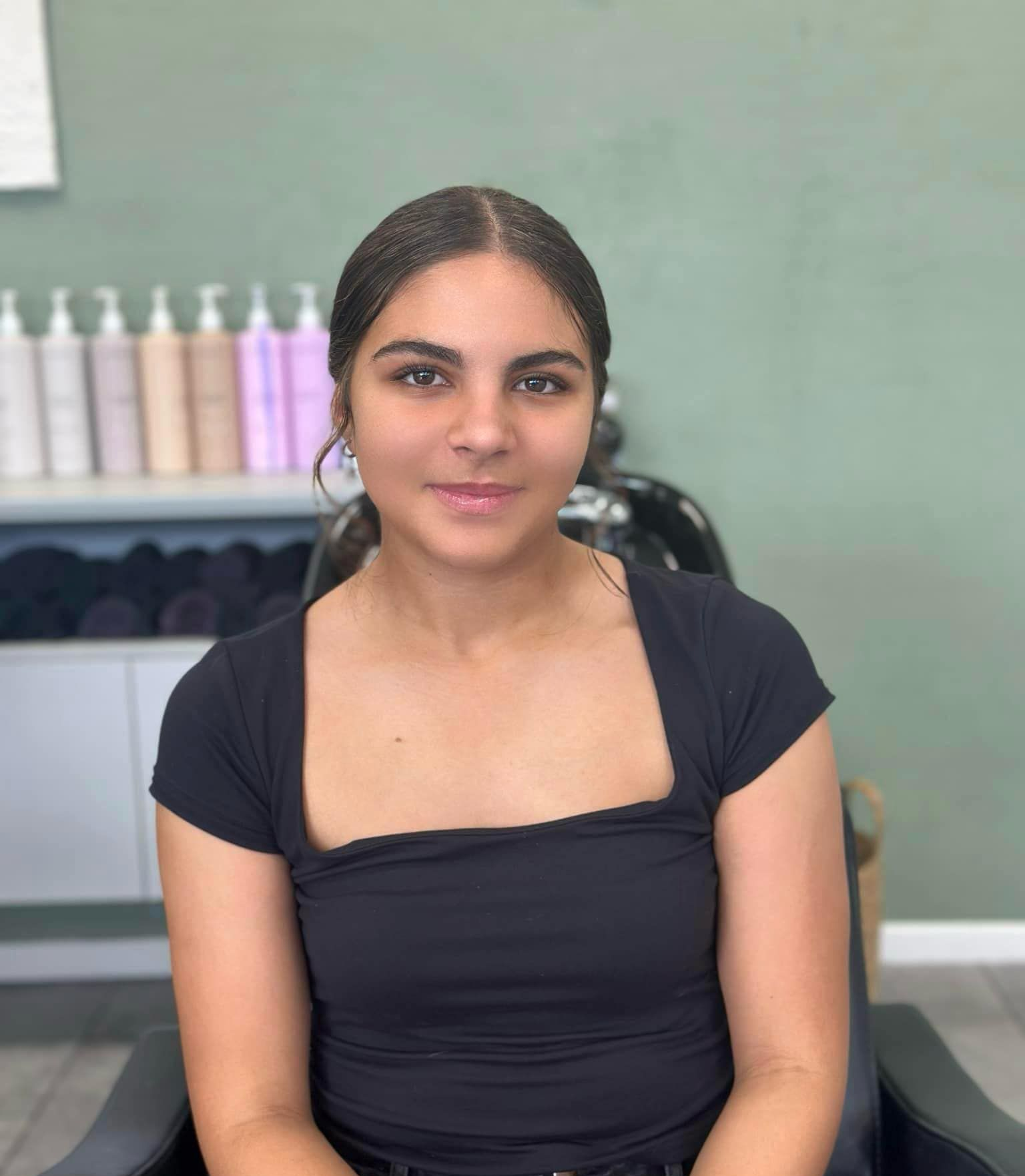 Young woman with dark hair and a smile in a salon setting — Blackwell Hair In Woree, QLD