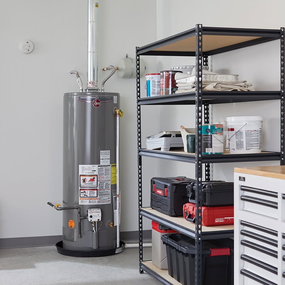 Utility room with a gray water heater beside black metal shelves holding tools and supplies.