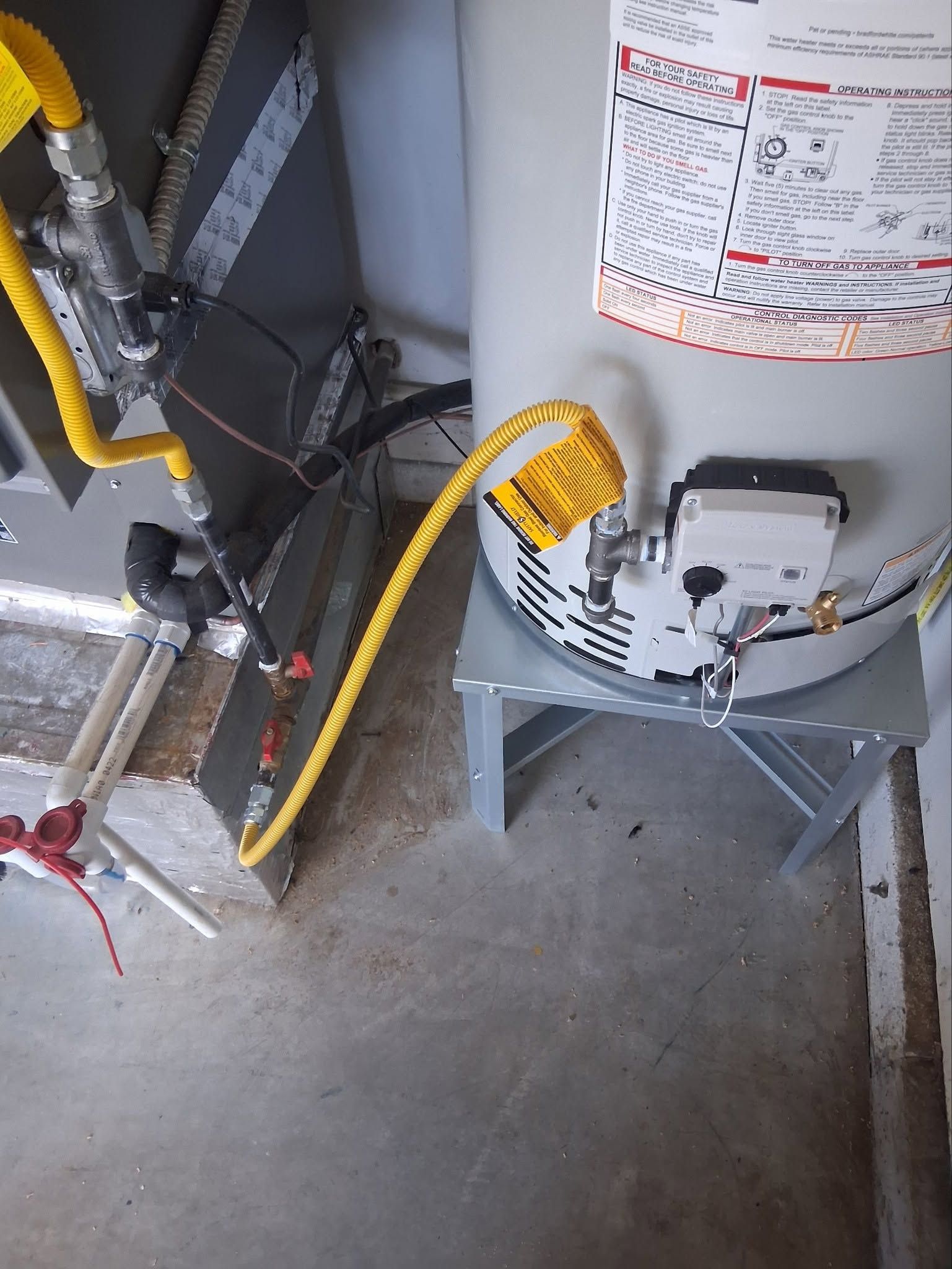 Yellow gas hose connected to a wall-mounted meter above a concrete floor in a utility room