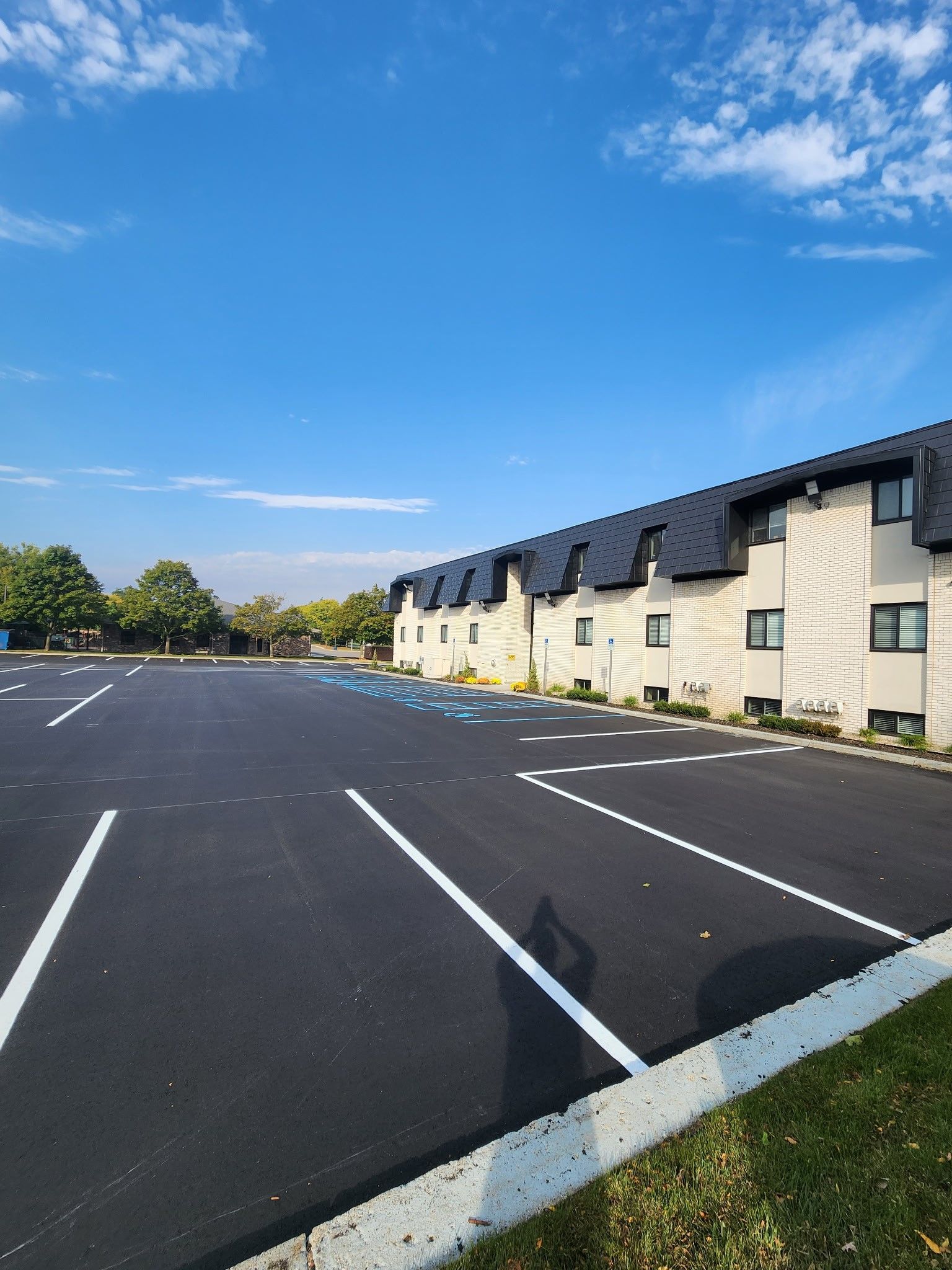A parking lot in front of a building with a blue sky in the background.