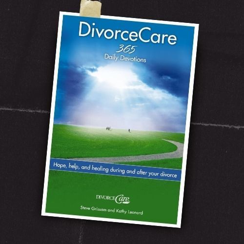 DivorceCare 365 daily devotional booklet on a dark surface, with blue sky and green field cover