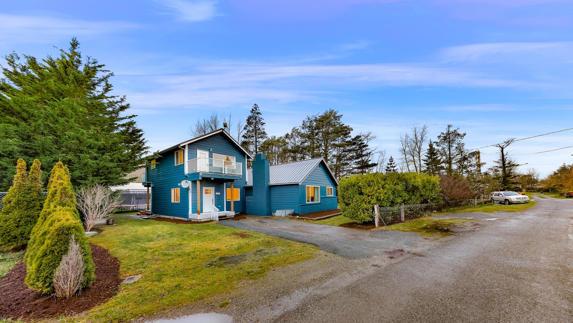 Street view of 2155 Postal Avenue with yard and surrounding trees.
