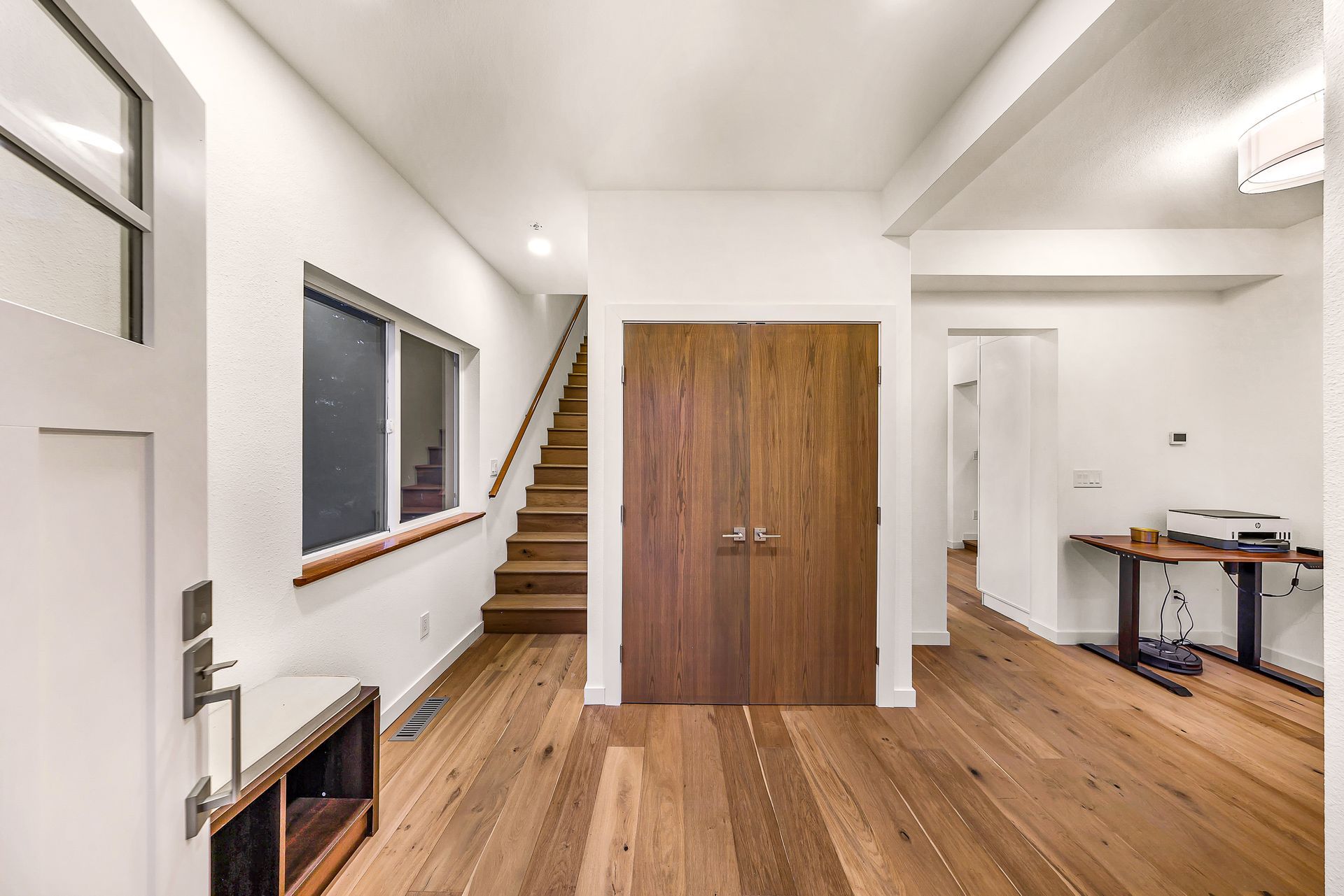 Entryway at 2155 Postal Avenue with wood floors, staircase, and double doors.
