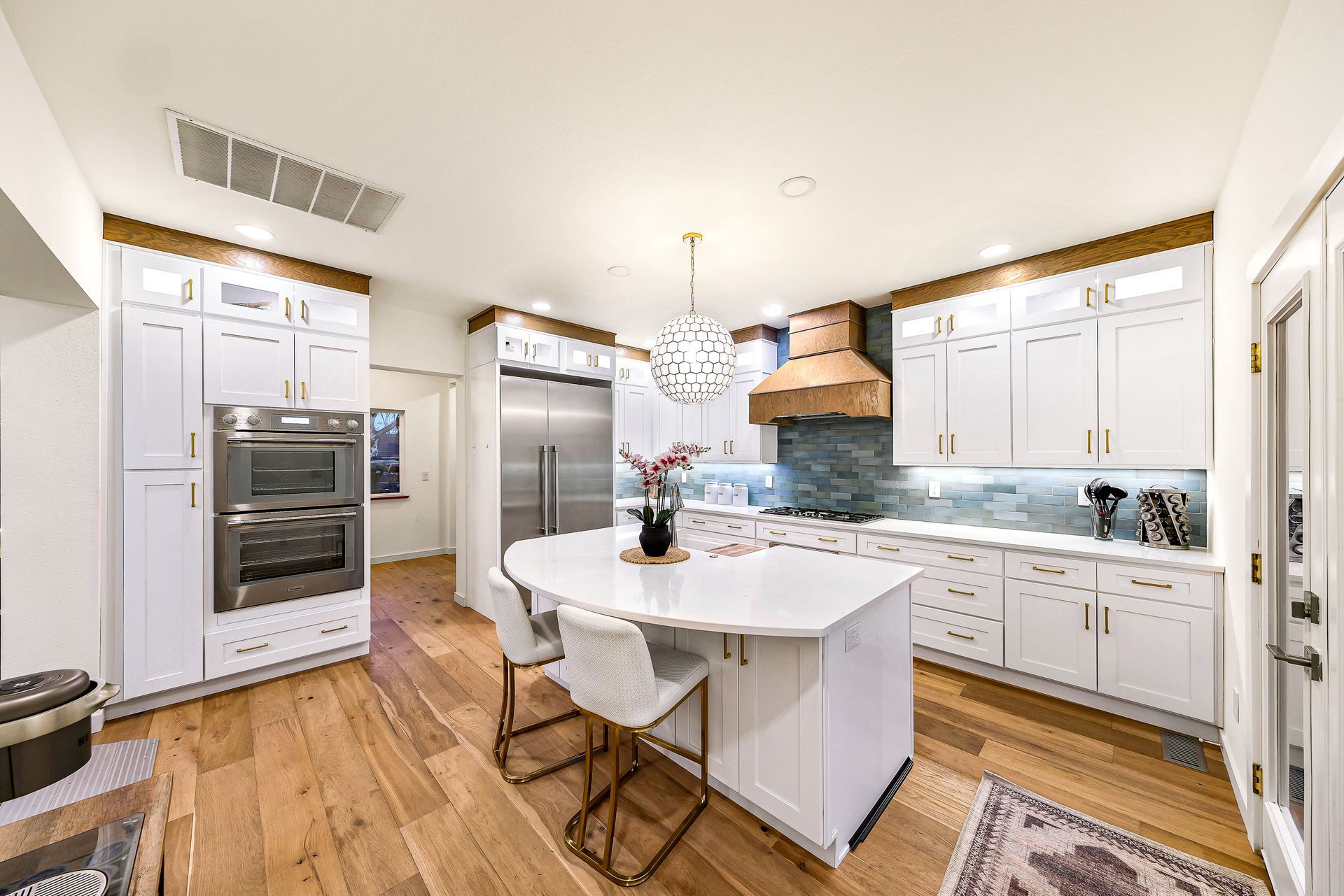 Kitchen with double ovens, built-in fridge, and custom cabinets.
