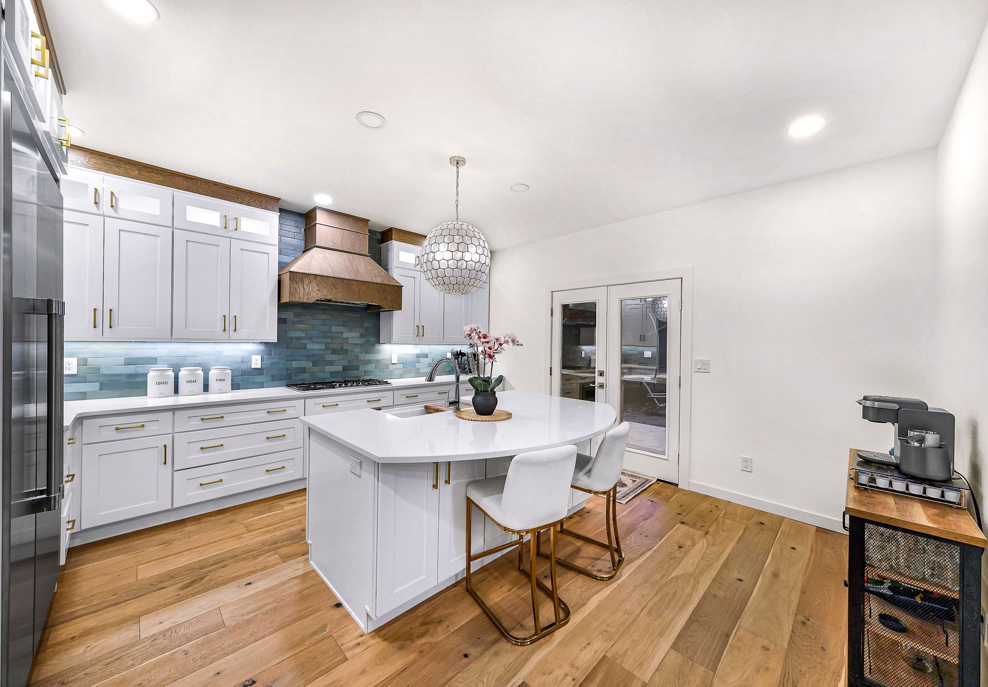 Modern kitchen with white cabinets, quartz countertops, and an island.
