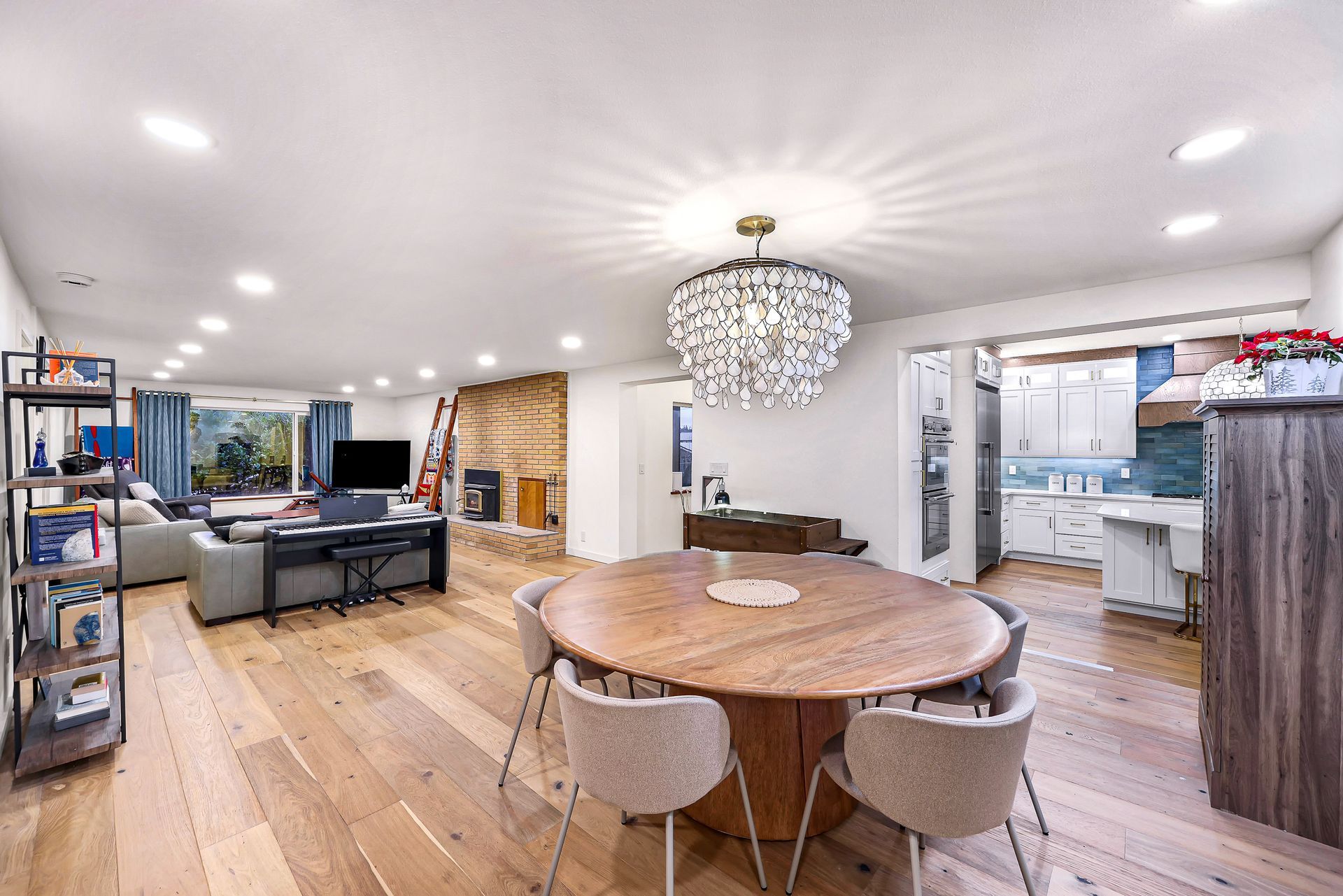 Open dining area with chandelier and view of living spaces.
