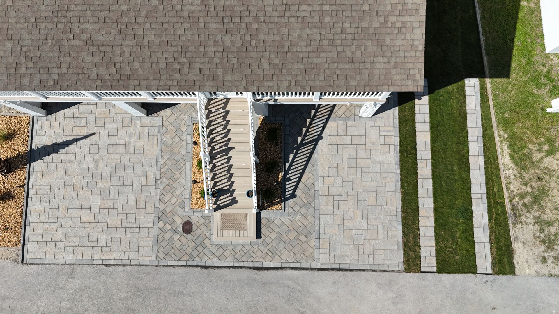 Brick house with a patio featuring wooden furniture, a fire pit, and a small white fence.