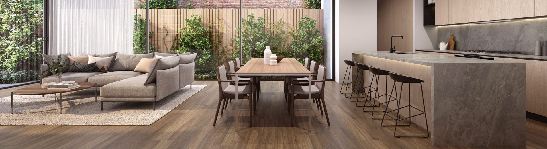Modern living room with a sofa, dining table, and kitchen island. Neutral colors and natural light.