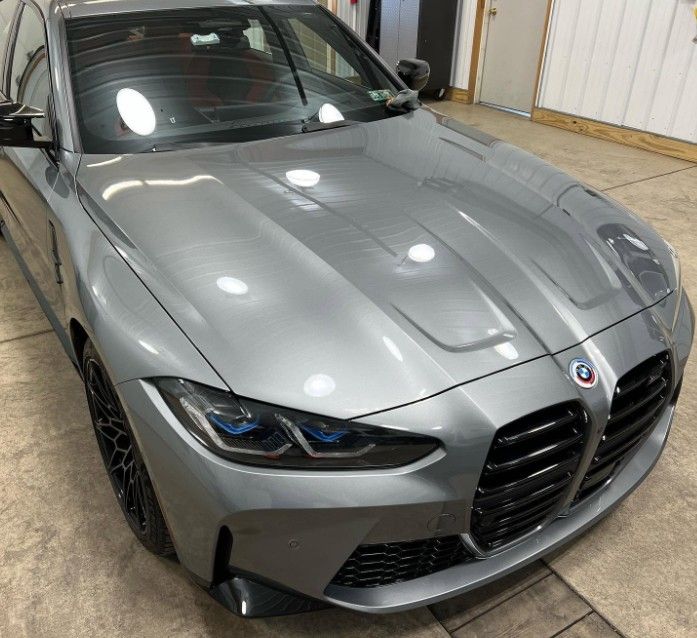 Silver BMW sedan parked indoors in a garage, front-left view.