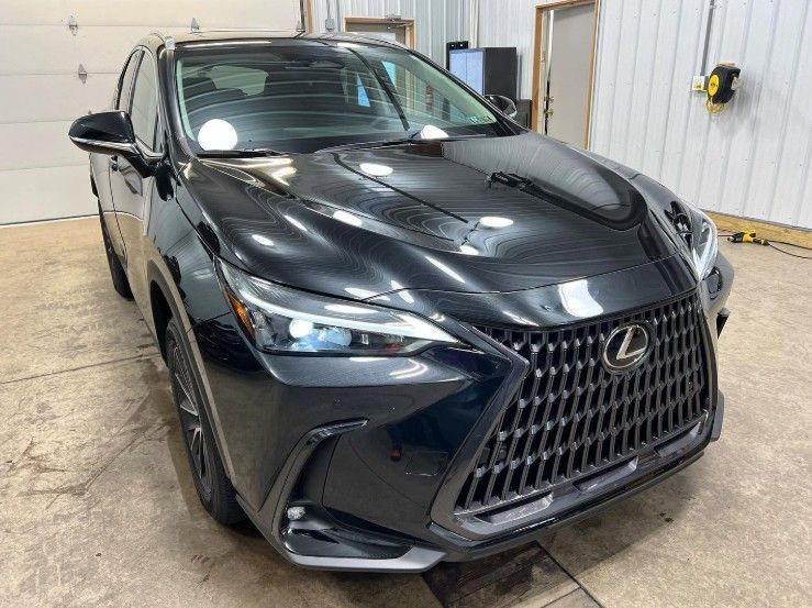 Black Lexus SUV parked in a garage, front view with chrome grille and glossy hood