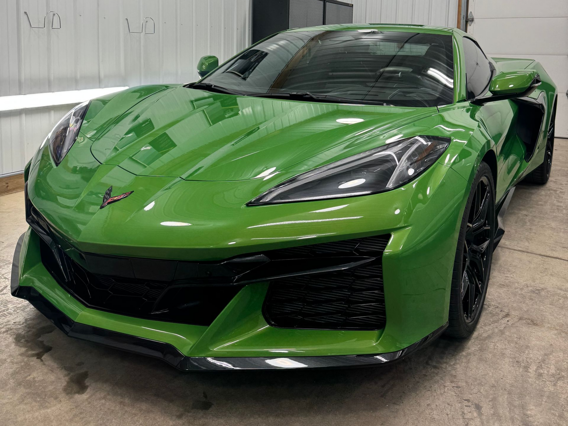 A lime green Chevrolet Corvette Z06 parked inside a garage.