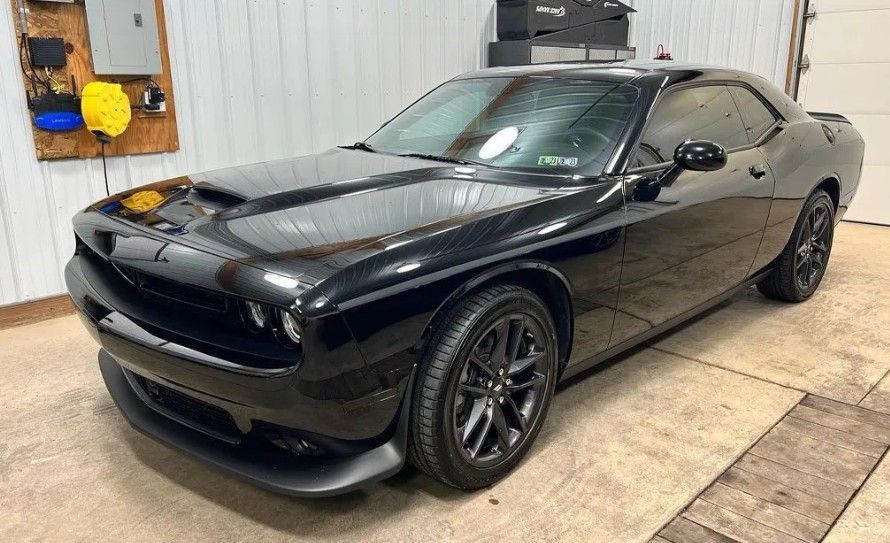 Black Dodge Challenger car parked inside a garage.