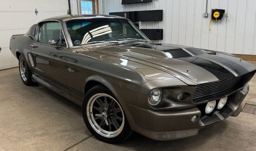 Grey 1967 Shelby GT500 with black stripes, in a garage.