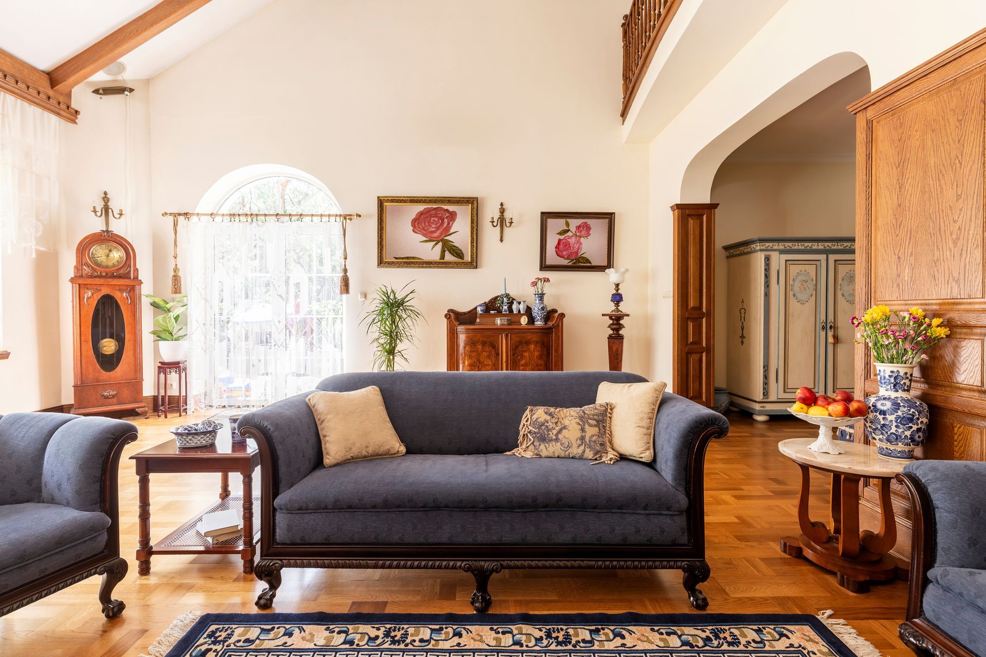 A traditional interior design style with an arched window and sheer shades