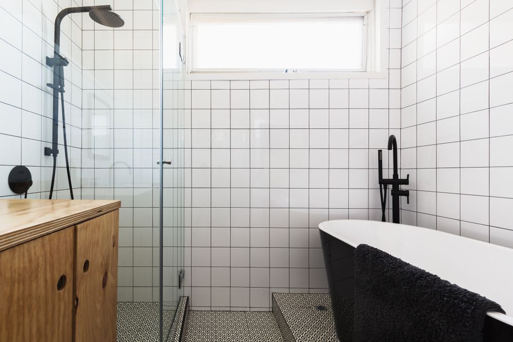 A Bathroom With a Bathtub, Shower, and Window — Leemark Design Services In Edmonton, QLD