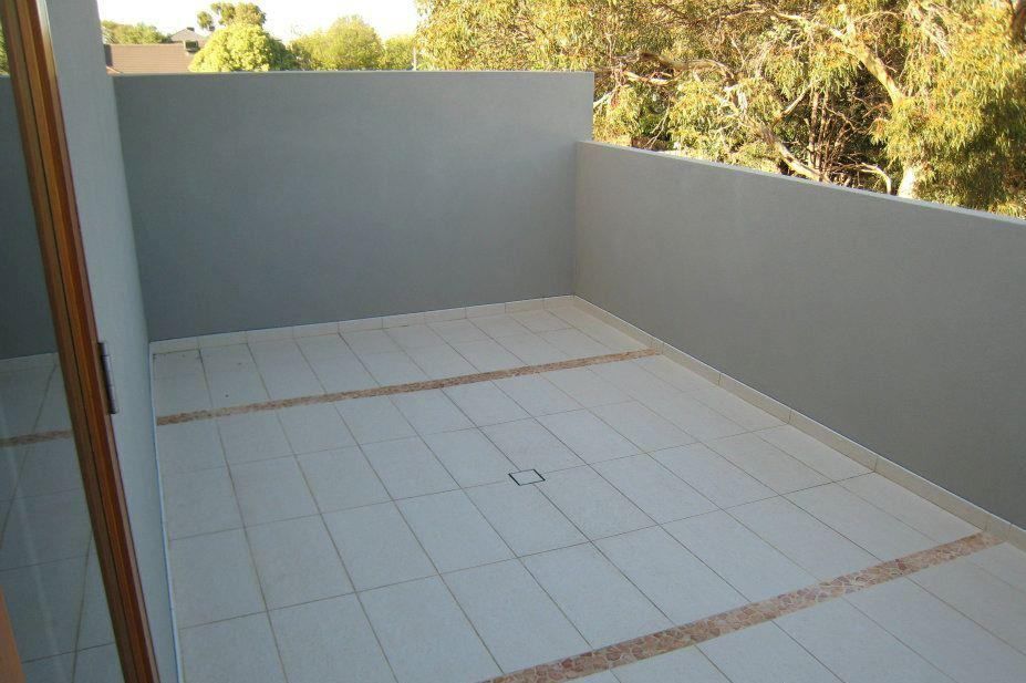 An Empty Balcony With White Tiles And Trees In The Background — Leemark Design Services In Parramatta Park, QLD
