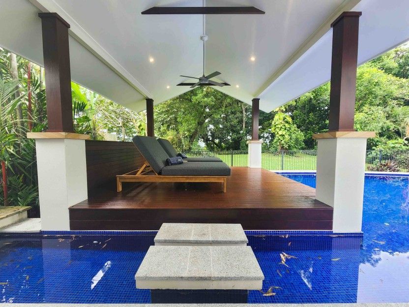 A Gazebo Overlooking a Swimming Pool With Chairs and a Ceiling Fan — Leemark Design Services In Parramatta Park, QLD