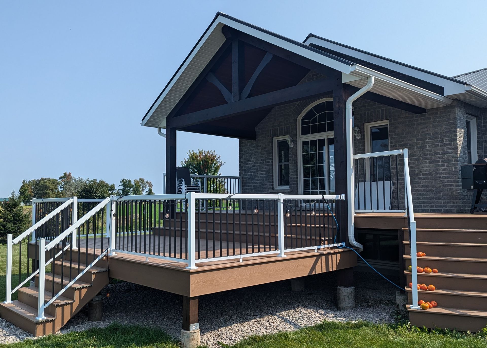 Front porch ramp and stairs on a brick house with white railings under a covered entry