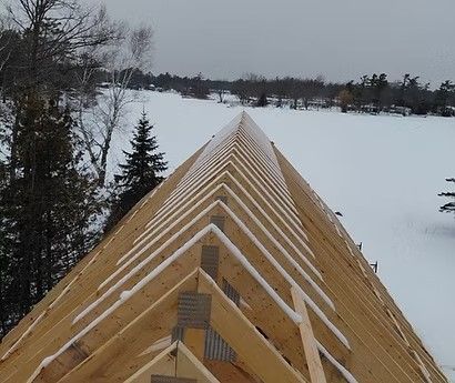 Rooftop under construction covered in snow, overlooking a frozen landscape