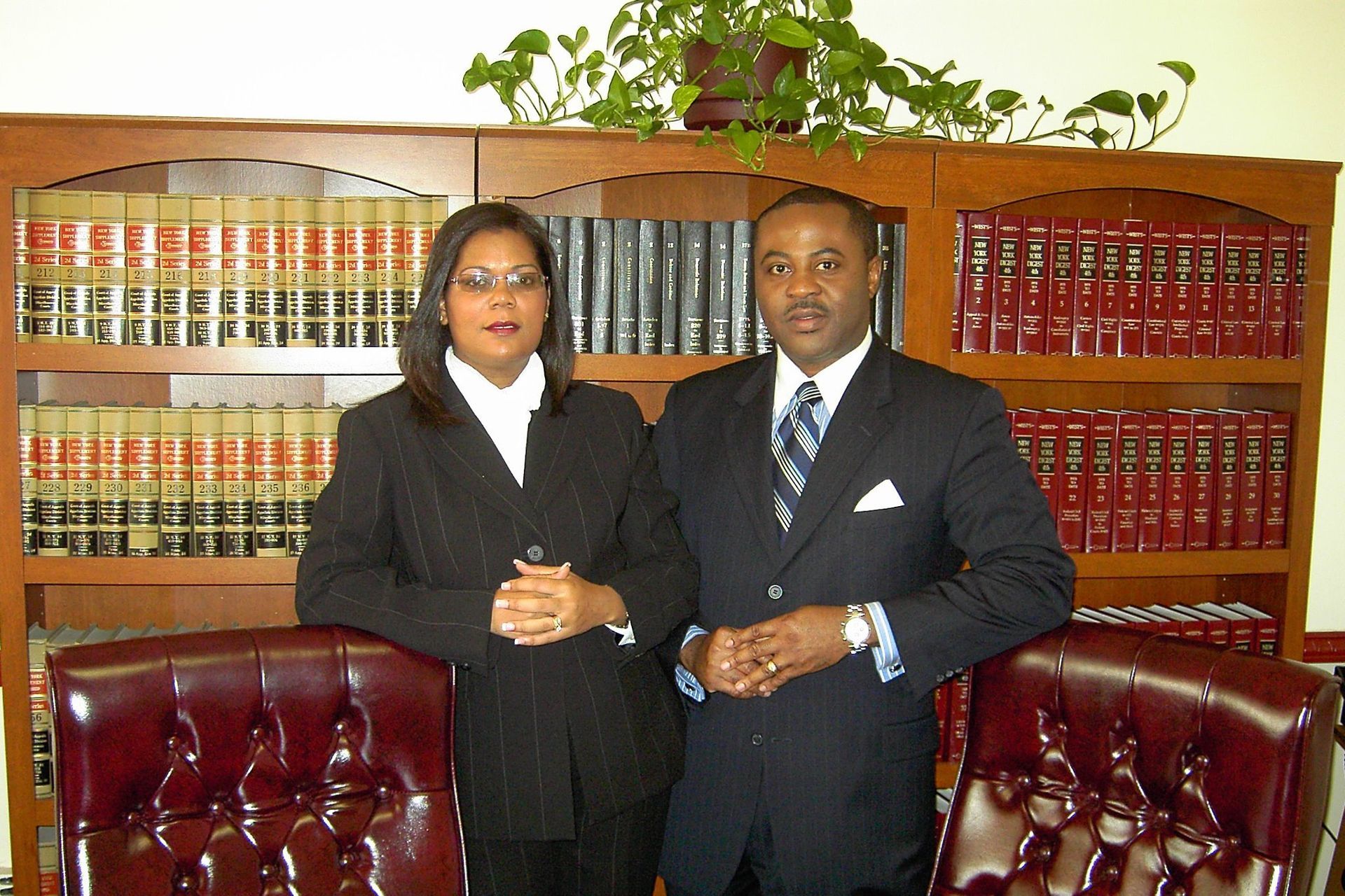 A man and a woman standing in front of a bookshelf