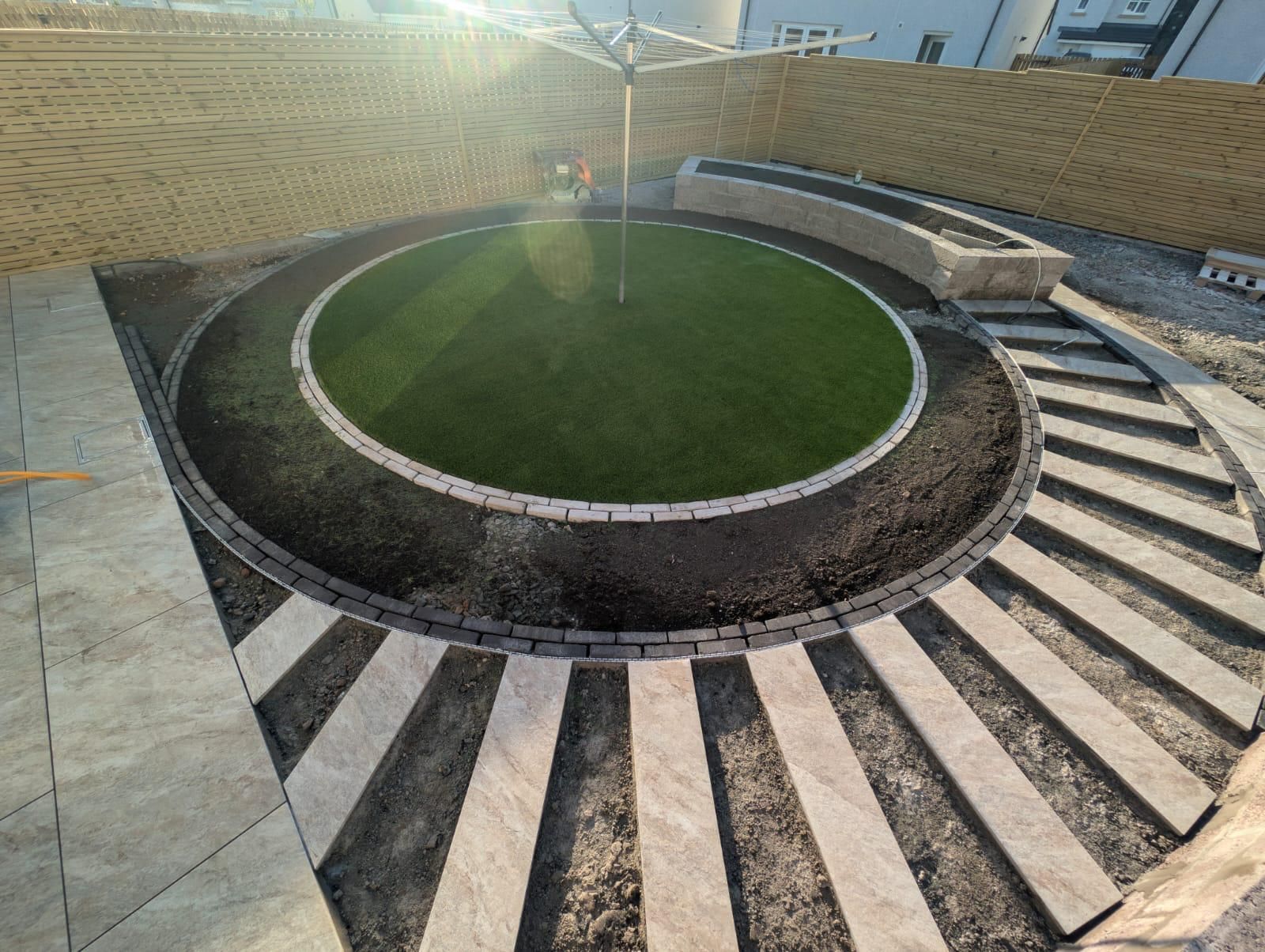 Circular artificial lawn and curved garden path nearing completion in Croy