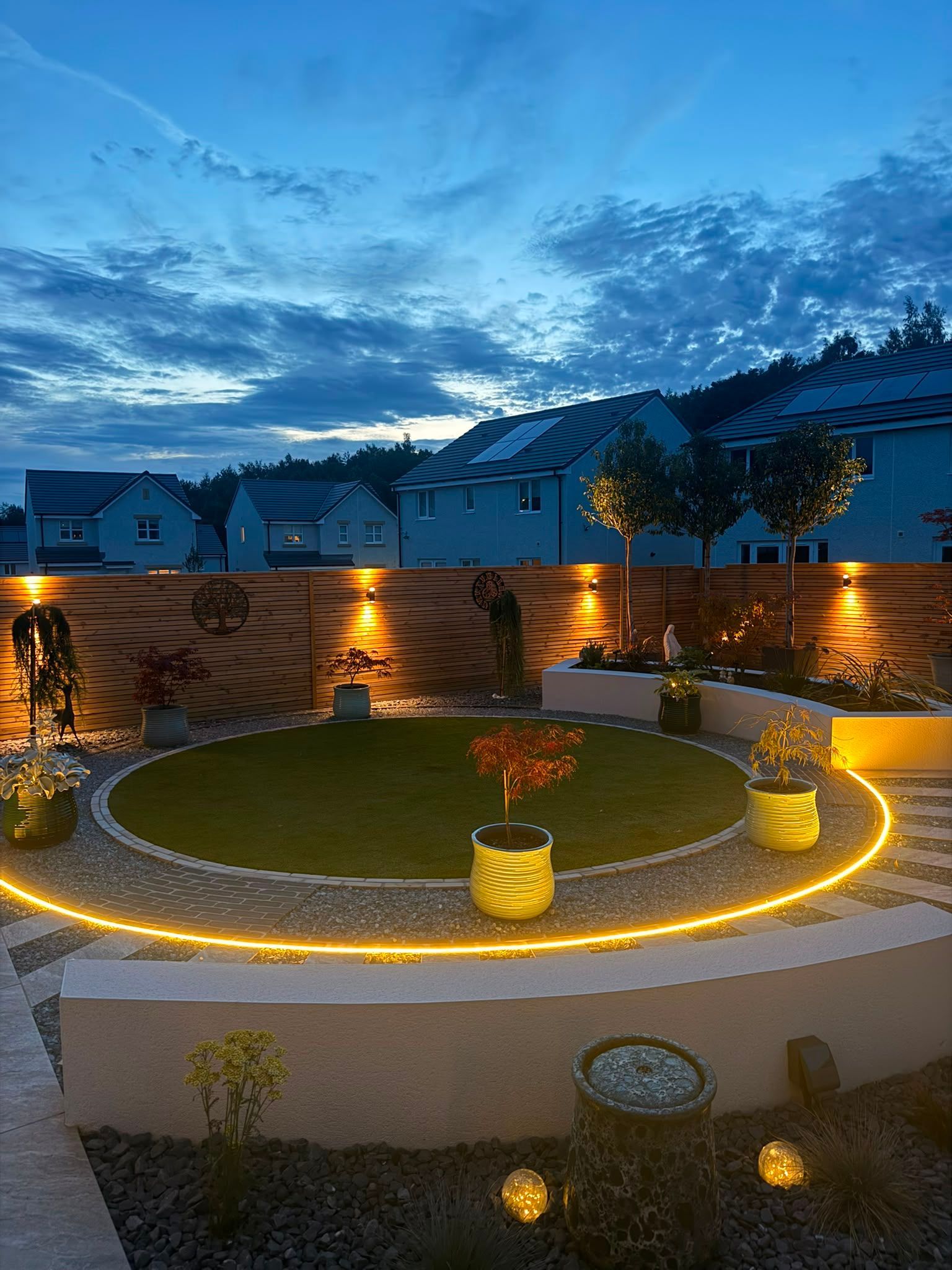 Completed circular lawn with illuminated planting and timber screening in Croy