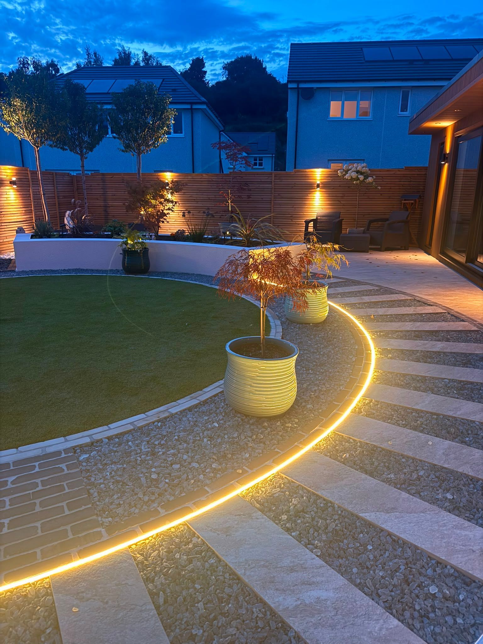 Illuminated curved pathway and completed landscaped garden in Croy at night