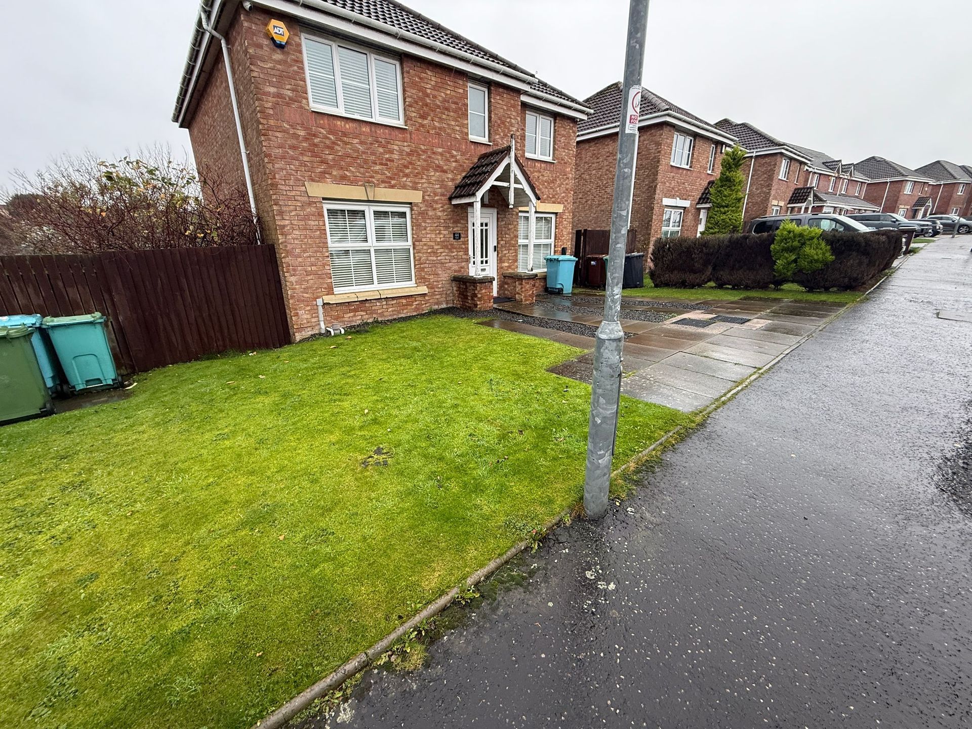 Glenboig property before driveway construction with lawn and narrow slab parking areas
