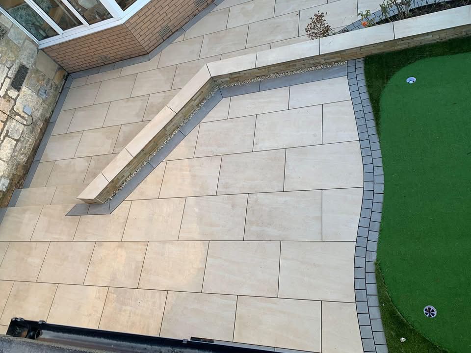 Large porcelain patio installation in Glasgow with curved edging, clean paving lines and low-maintenance garden finish.