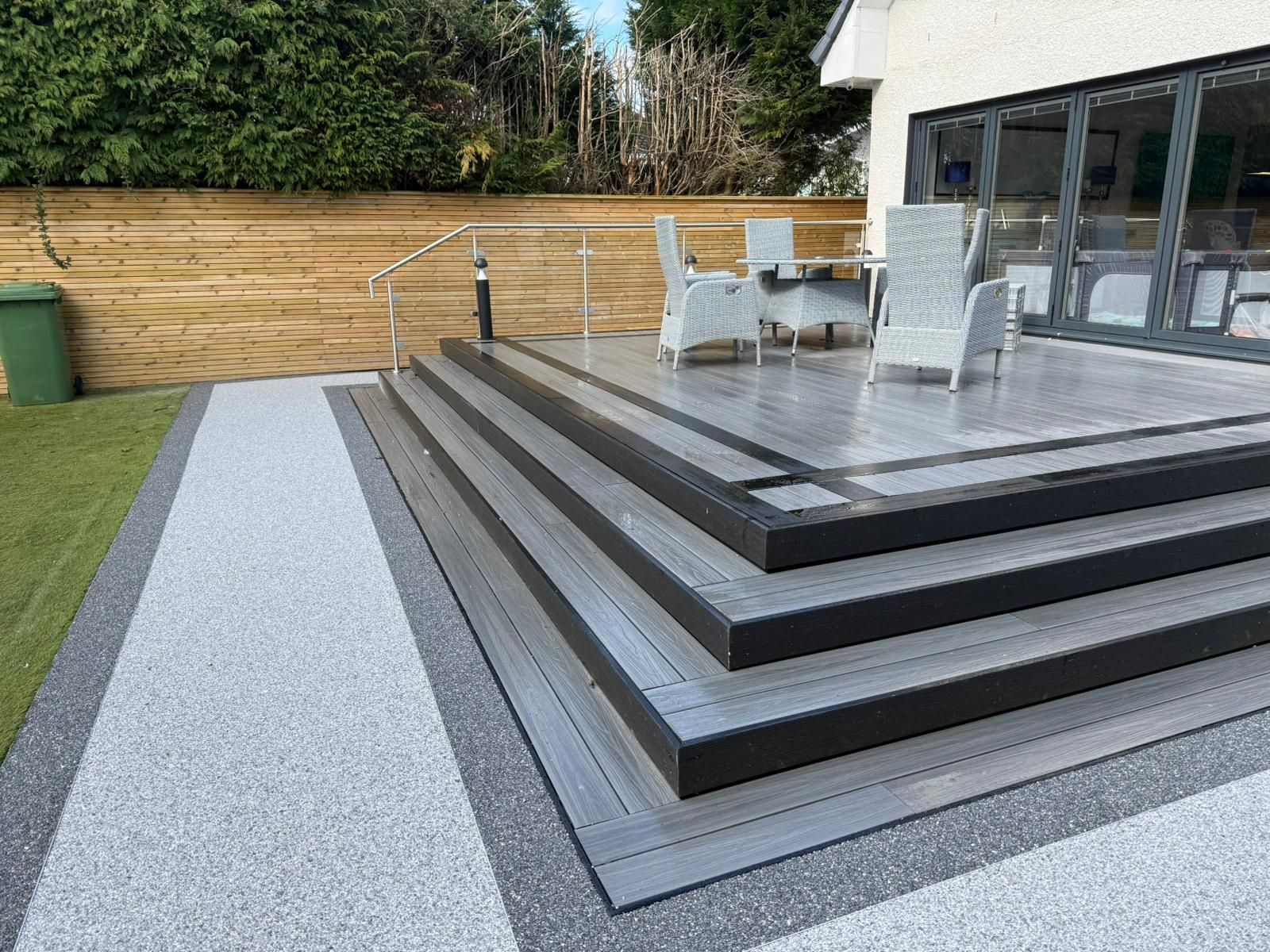 Modern garden patio in Glasgow with composite decking, resin boundary, paving, steps and outdoor seating area