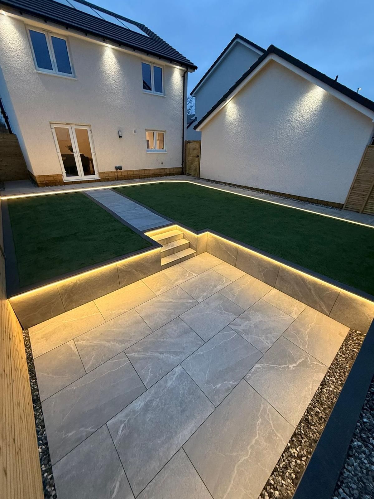 Patio installation in Glasgow with outdoor lighting, rendered walls and artificial lawn detail.
Small bottom left image