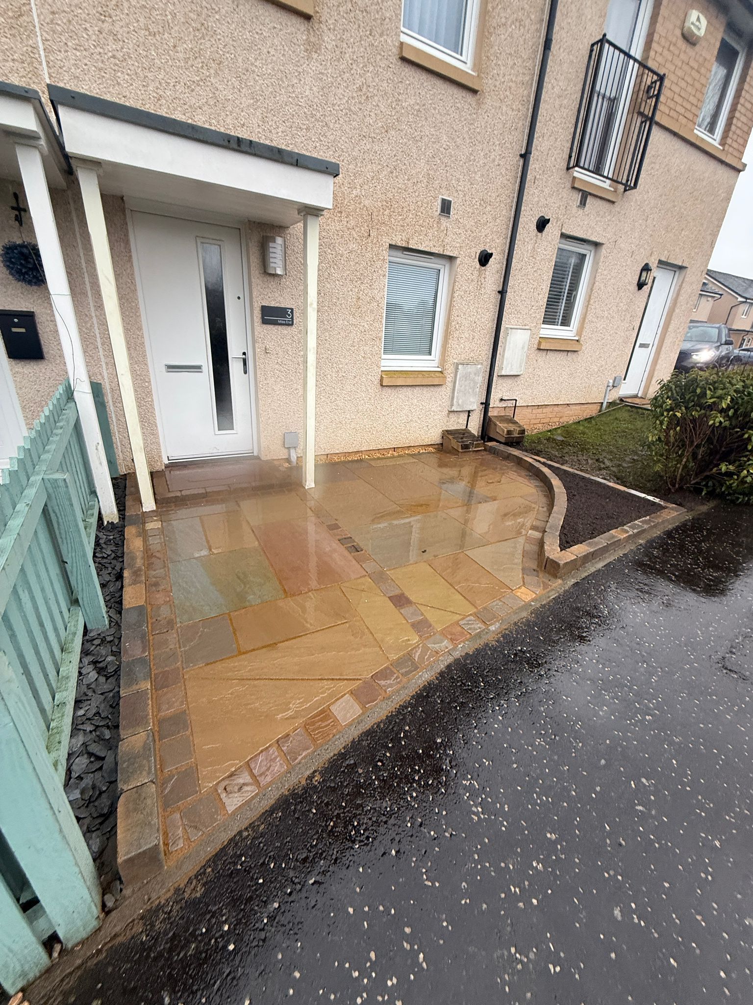 mall front garden patio in Glasgow with natural stone paving, drainage detail and access to the property.