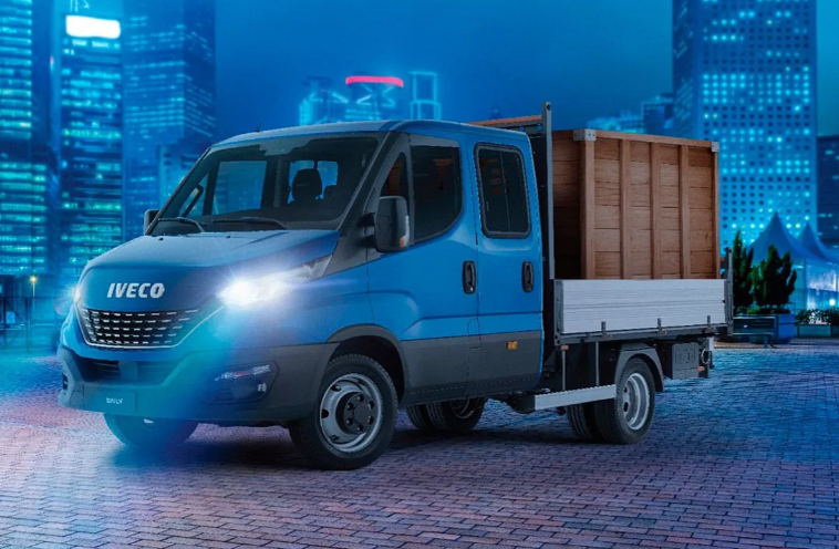 Camión Iveco azul con chasis cabina sobre fondo blanco, visto desde tres cuartos de frente.