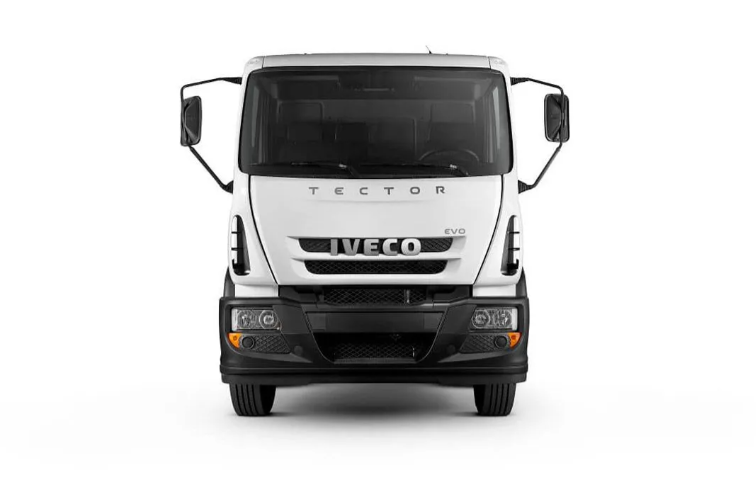 Chasis de camión Iveco blanco circulando por un camino polvoriento al atardecer.