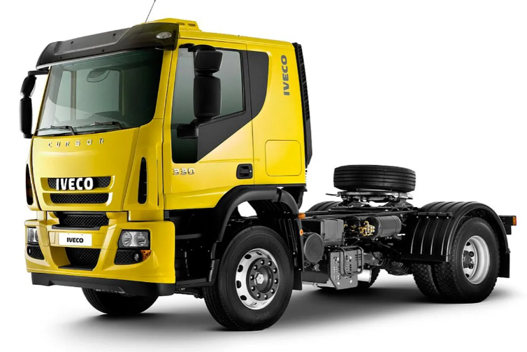 Un camión semirremolque Iveco morado circula por una autopista con un remolque negro.
