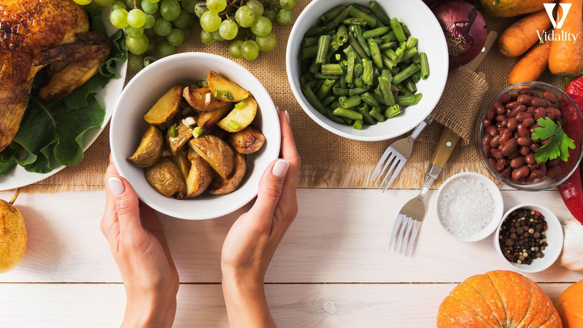 A person holding a plate of food with a variety of colorful vegetables and fruits.