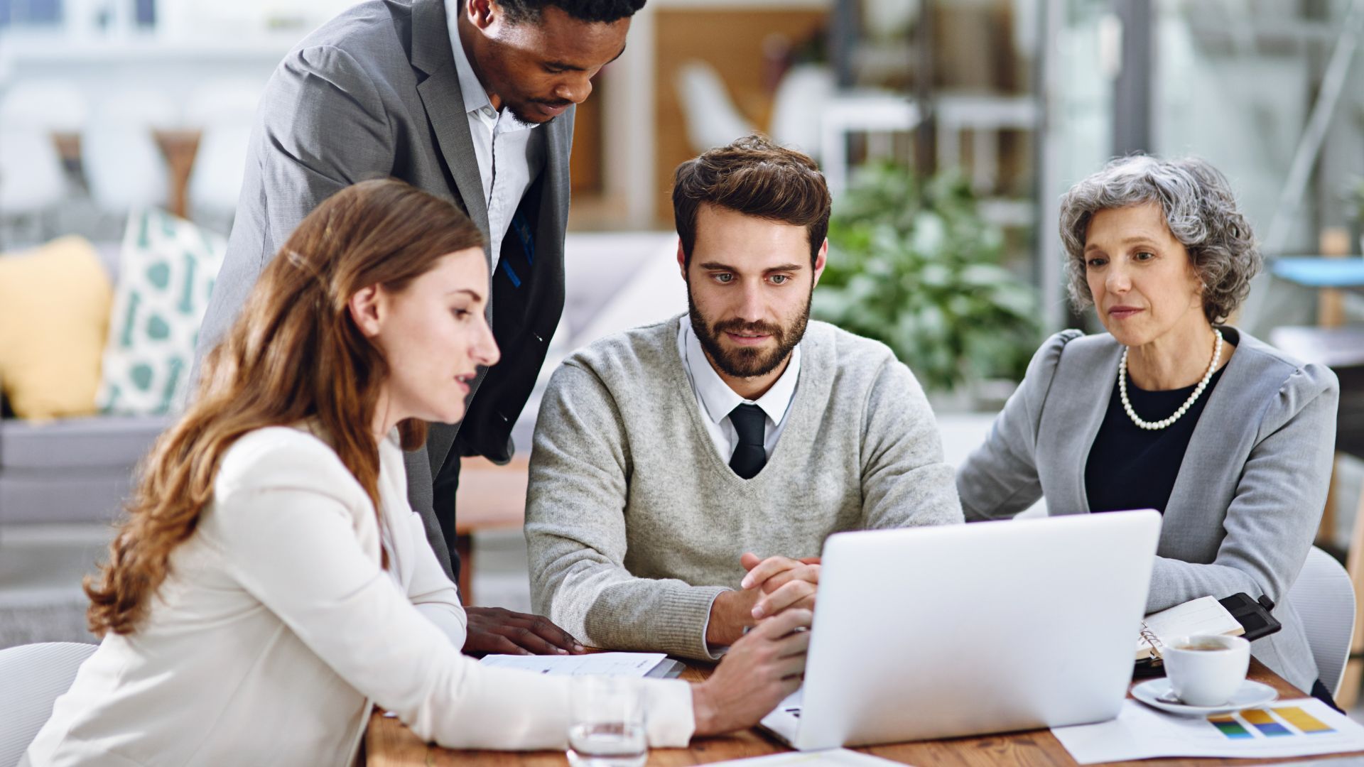 A team of professionals collaborating on a laptop