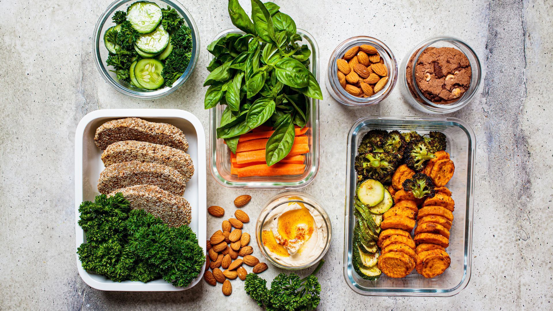 A variety of healthy food in containers, including fruits, vegetables, and lean proteins.