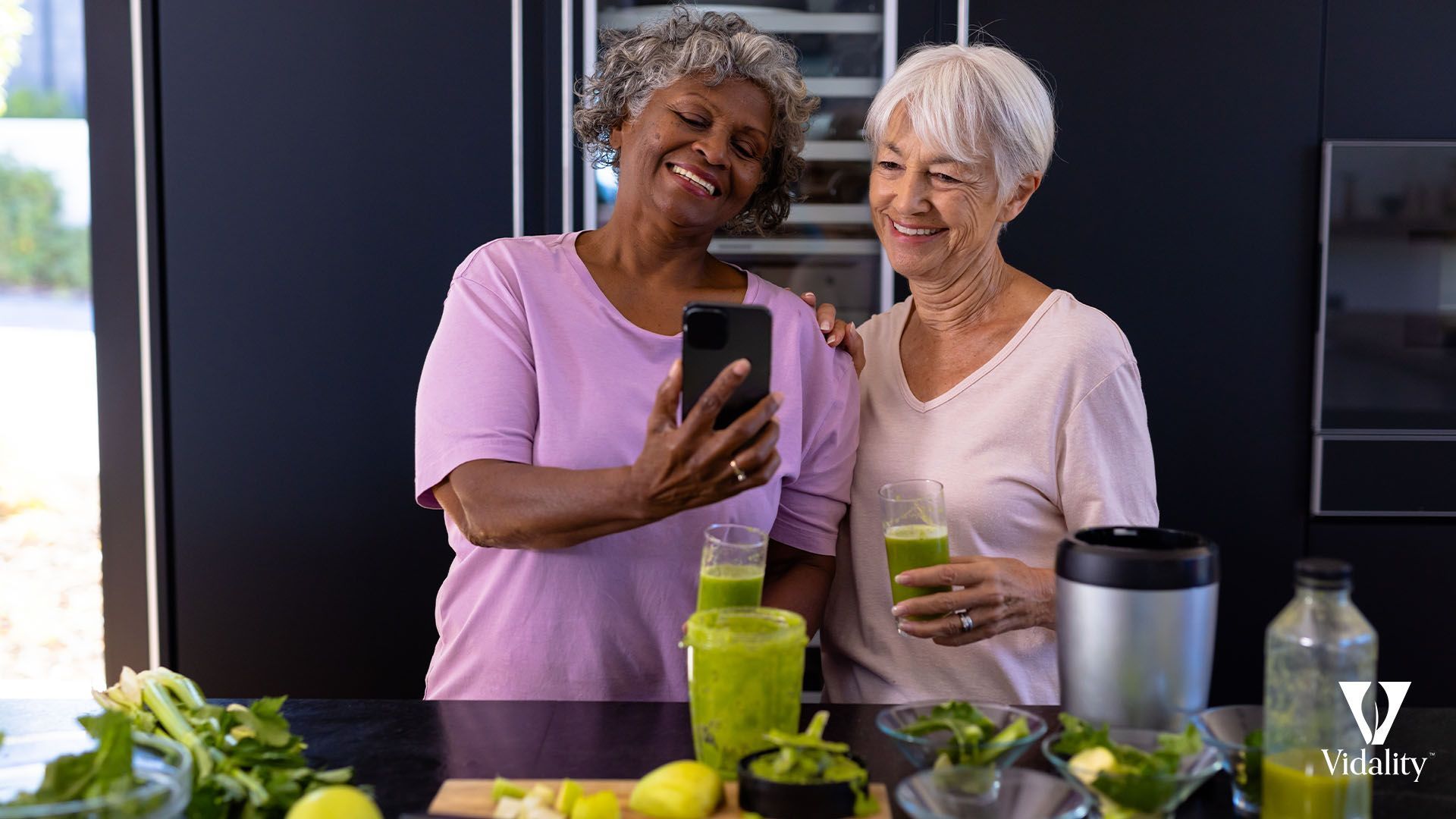 Two elderly women smiling and posing for a selfie with a smartphone.